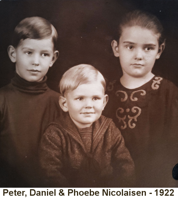 Sepia-tone photo of two young boys, Peter with brown hair in dark turtleneck sweater, Daniel with blond hair in sailor suit, and a young girl with dark hair pulled back tightly, wearing an embroidered blouse